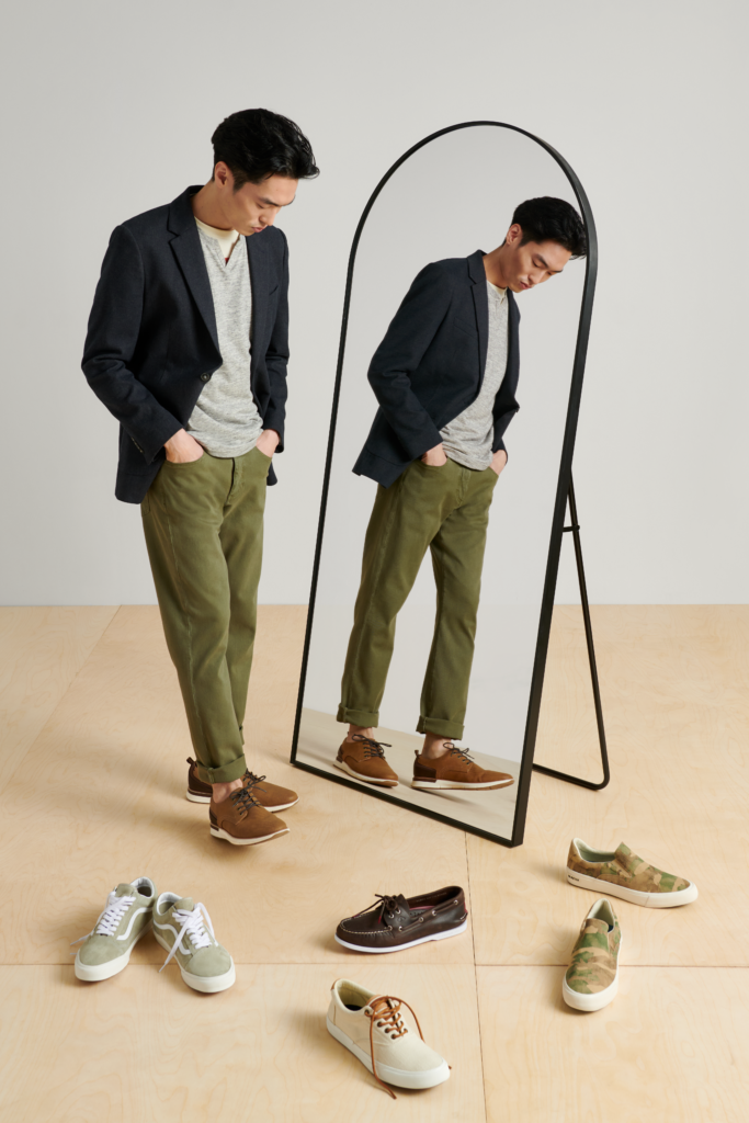 Stitch Fix model in front of a mirror trying on men’s fall shoes, including a brown sport-bottom pair.