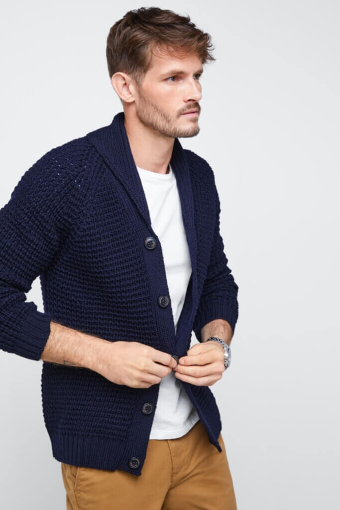 Stitch Fix Men’s model wearing a cardigan outfit with a white T-shirt, navy cardigan and tan pants.