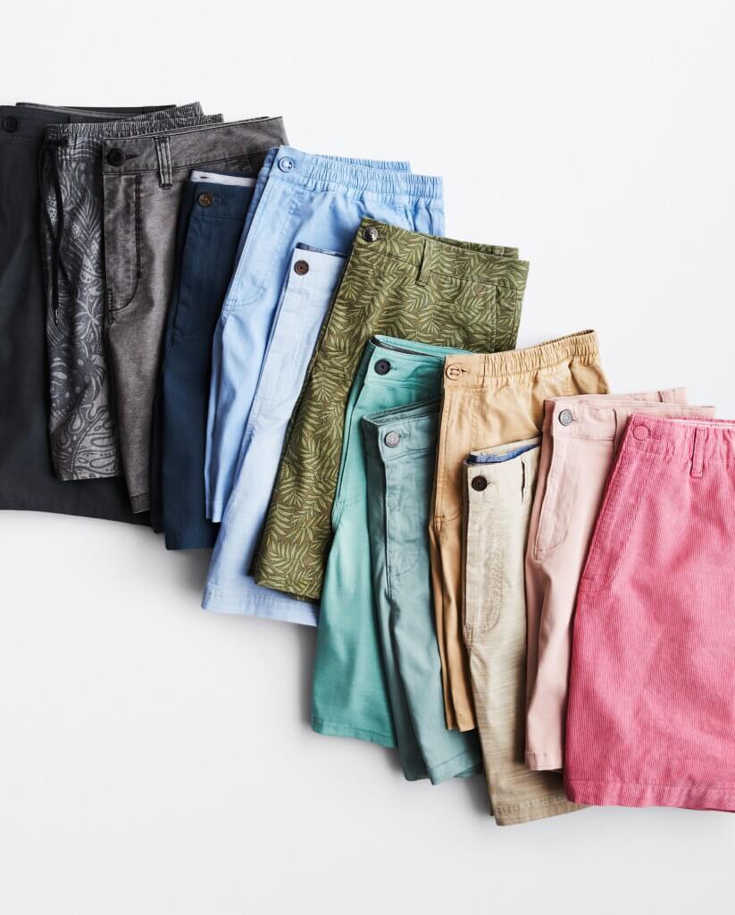 A neatly aligned row of chino shorts in multiple colors.