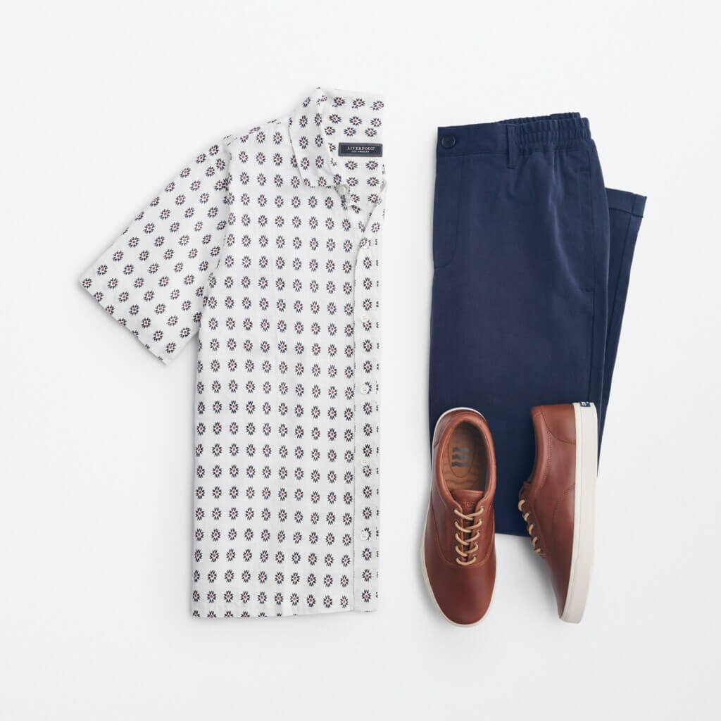 A top view of summer clothes: button-up shirt, chino pants and brown sneakers.