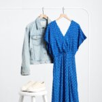 Stitch Fix blue maxi dress with conversation print on rack with light blue denim jacket and next to off-white sneakers.