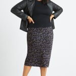 Stitch Fix model wearing plus-size clothing featuring microfloral pencil midi skirt, black knit top and black moto jacket.