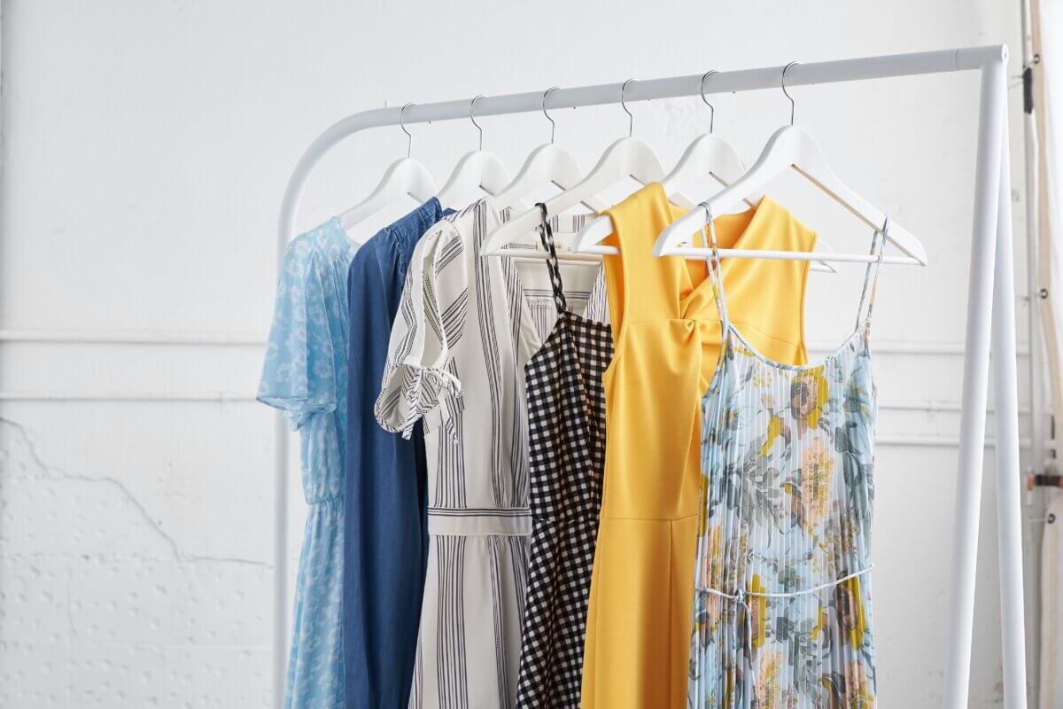 Stitch Fix maternity clothing collection featuring solid dresses in a variety of colors and prints hanging on rack.