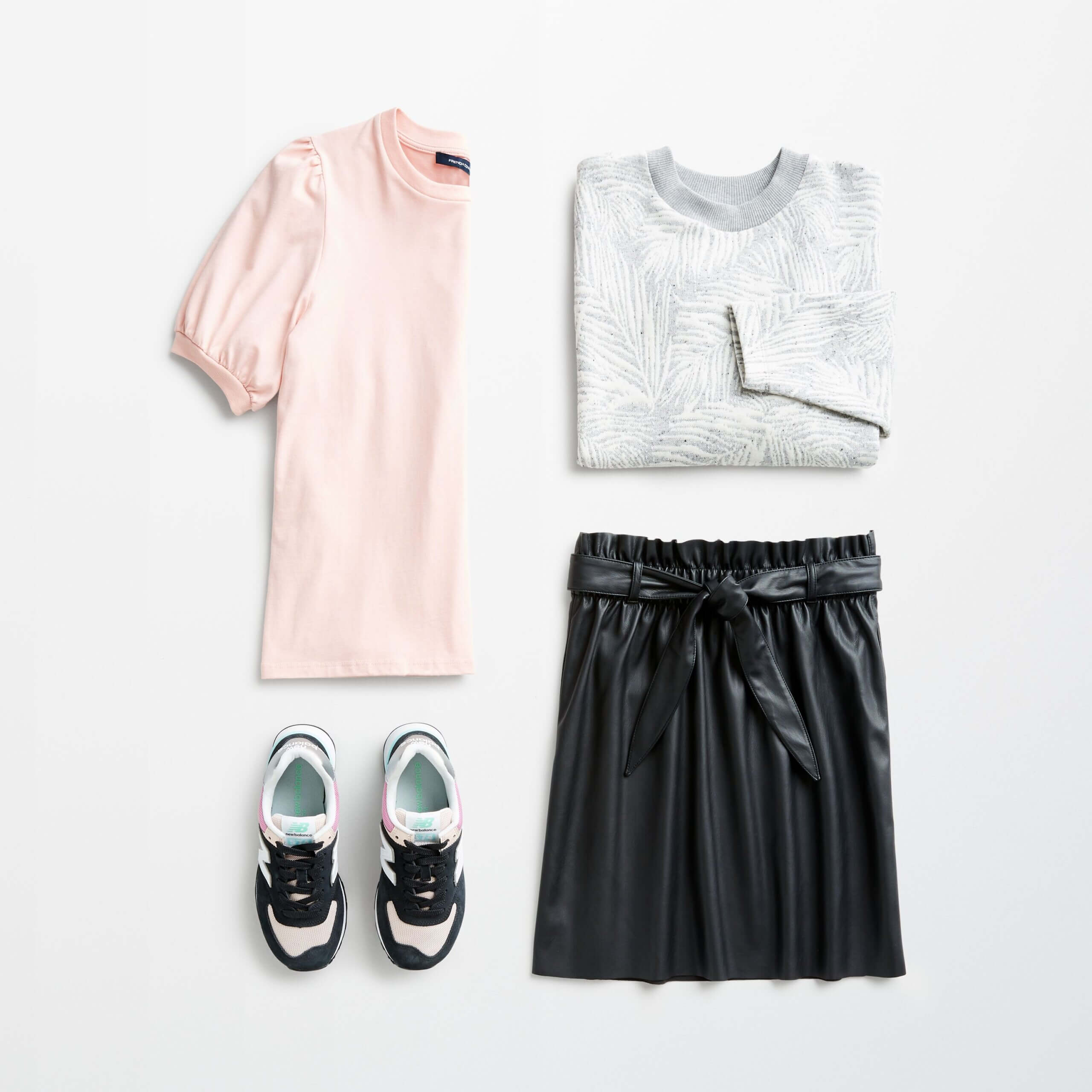 Stitch Fix Women’s Outfit featuring faux leather skirt, pink knit top, grey crewneck pullover and sneakers.