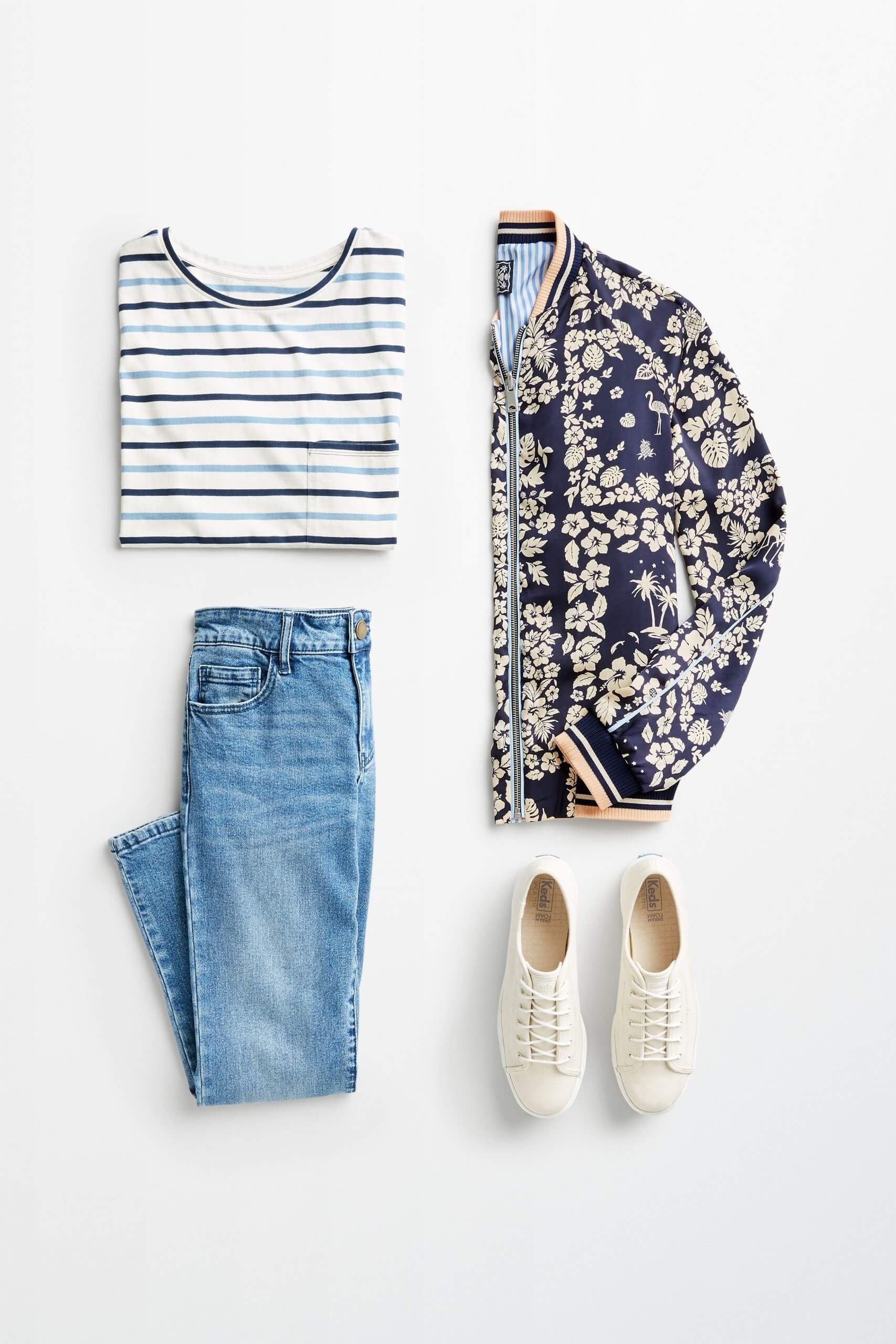 Stitch Fix women’s outfit laydown showing how to mix prints and patterns featuring a striped t-shirt, reversible bomber jacket, blue denim and off-white sneakers.