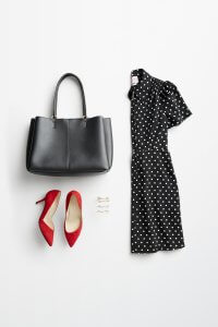 Stitch Fix women’s accessories to wear with black dress featuring silver and gold hair clips, red heels, black tote with black polka dot dress.