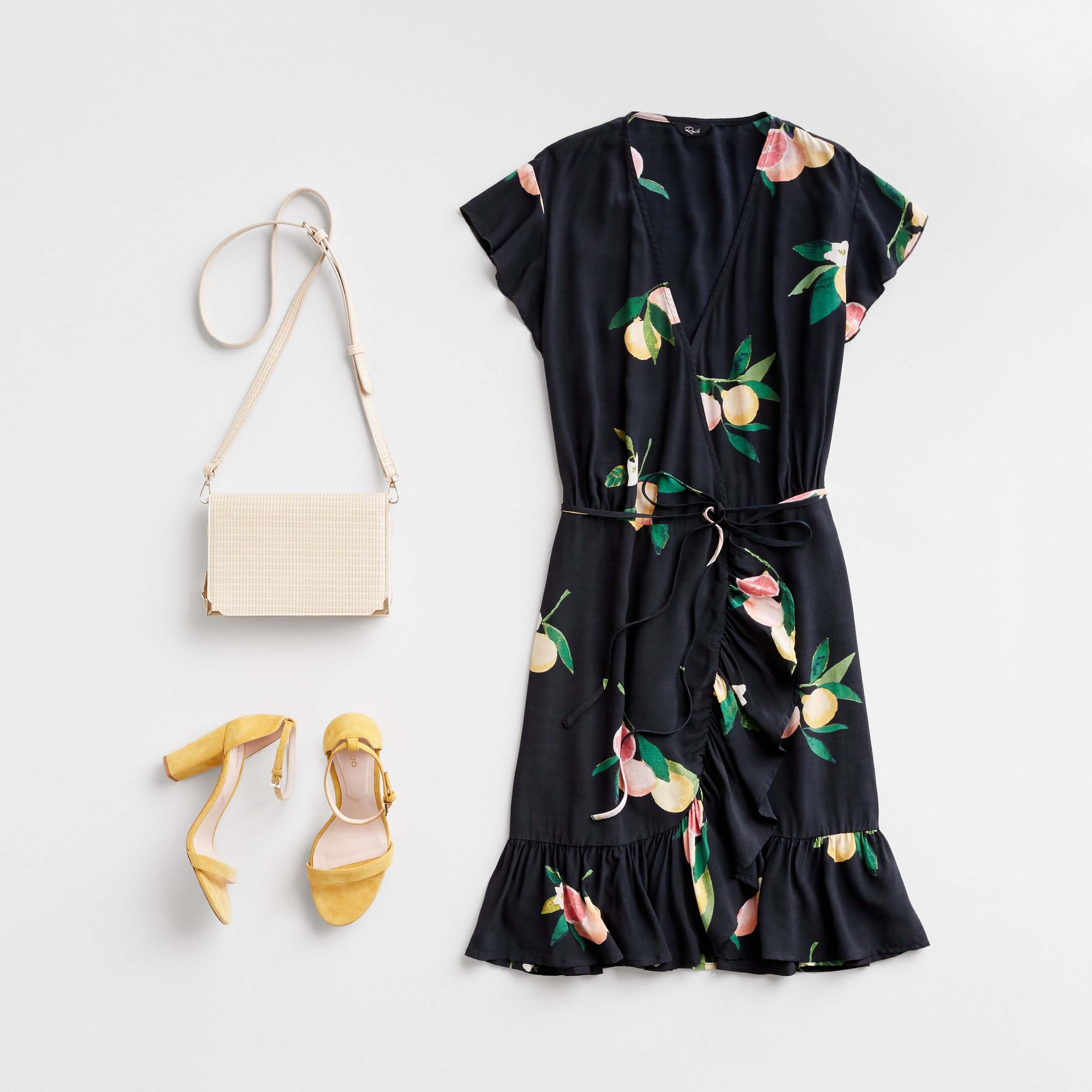 Stitch Fix Women's outfit laydown featuring black lemon-printed wrap dress with yellow block heels and cream crossbody bag.