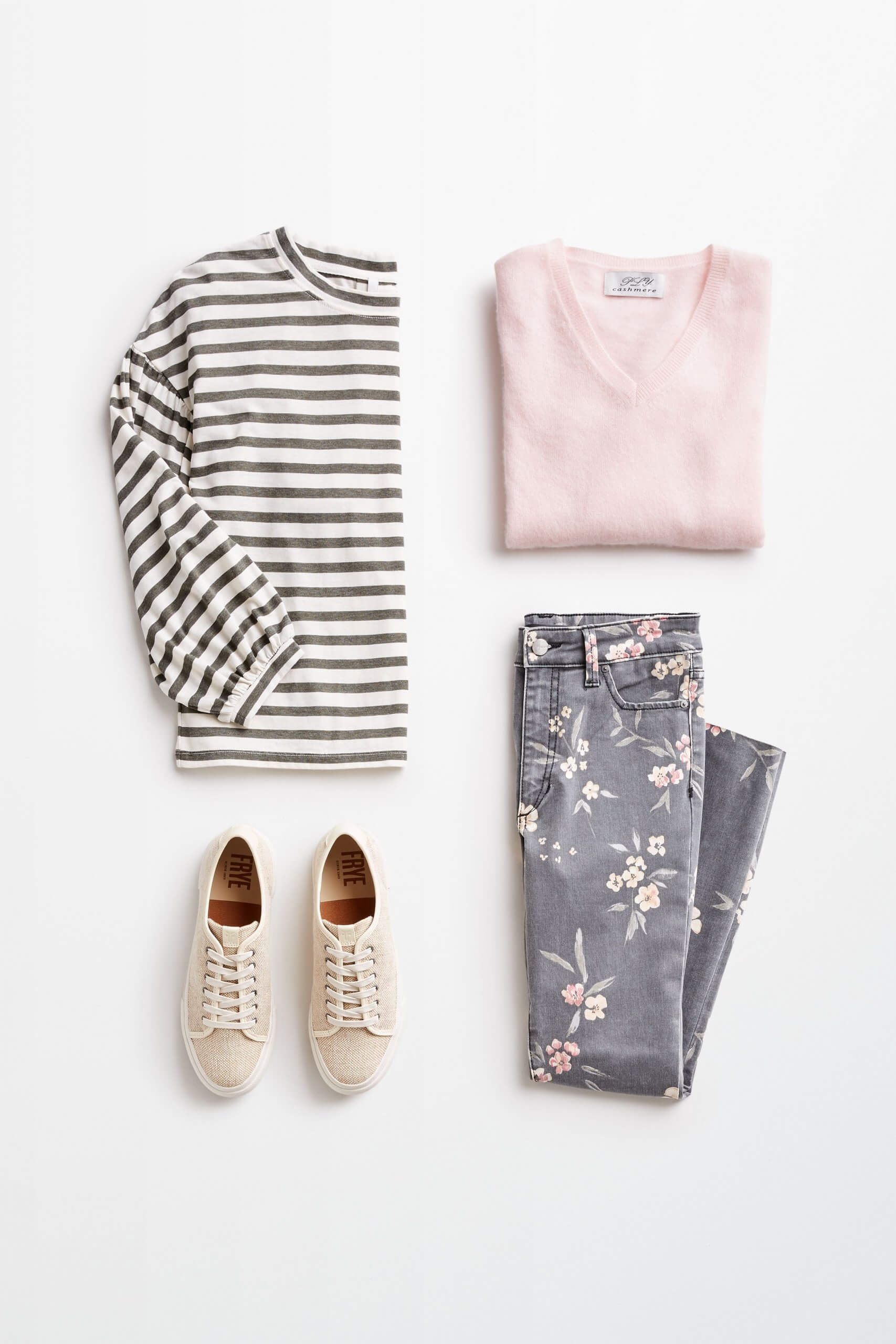 Stitch Fix women’s outfit laydown showing how to mix prints and patterns featuring striped top, floral printed denim, pink pullover and beige canvas sneakers.