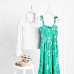 Stitch Fix Summer Cocktail Attire green floral dress with tie straps, white denim jacket and black and tan wedge shoes. 