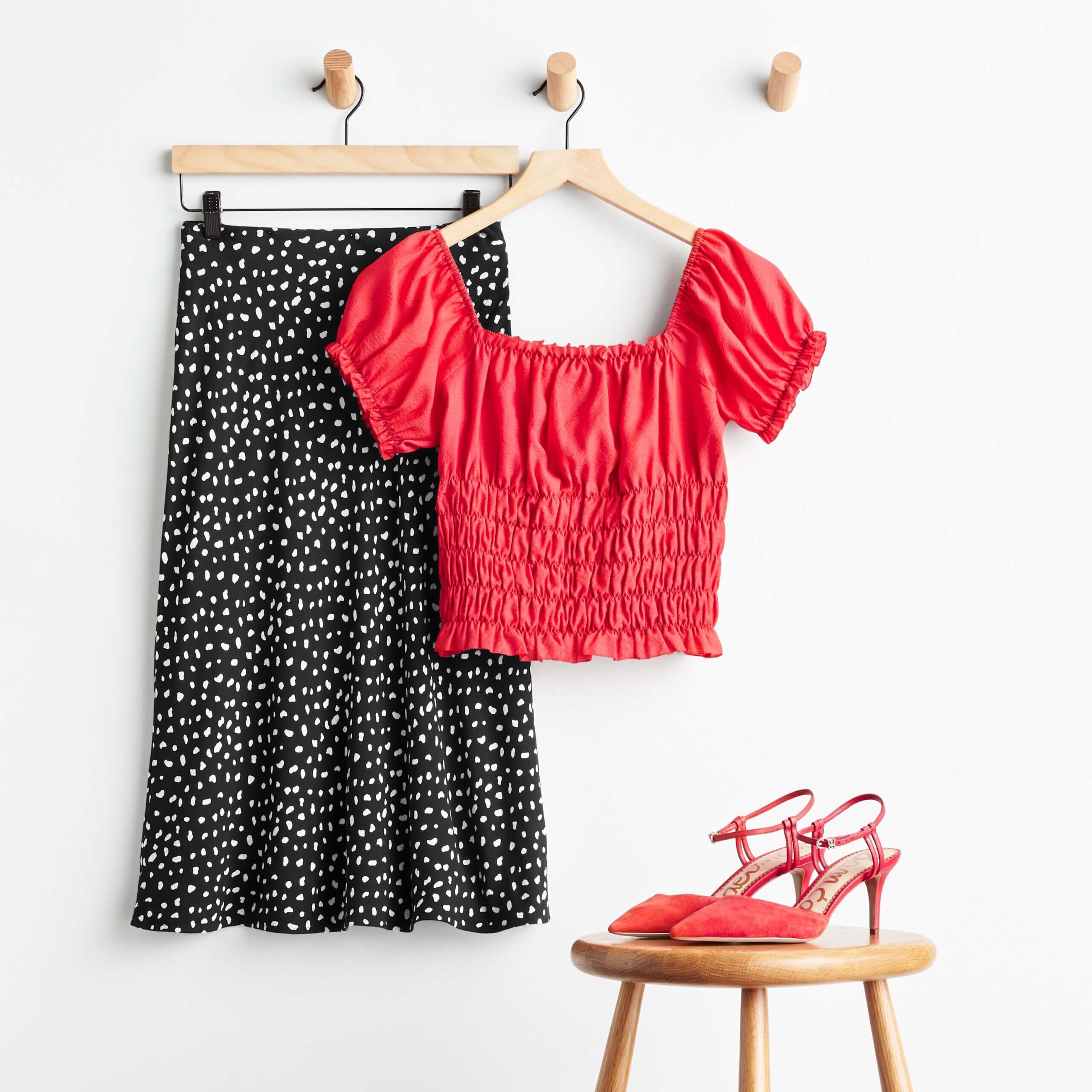 Stitch Fix Women’s date night at home featuring a red smocked blouse with black micro-dot midi skirt and red heels.