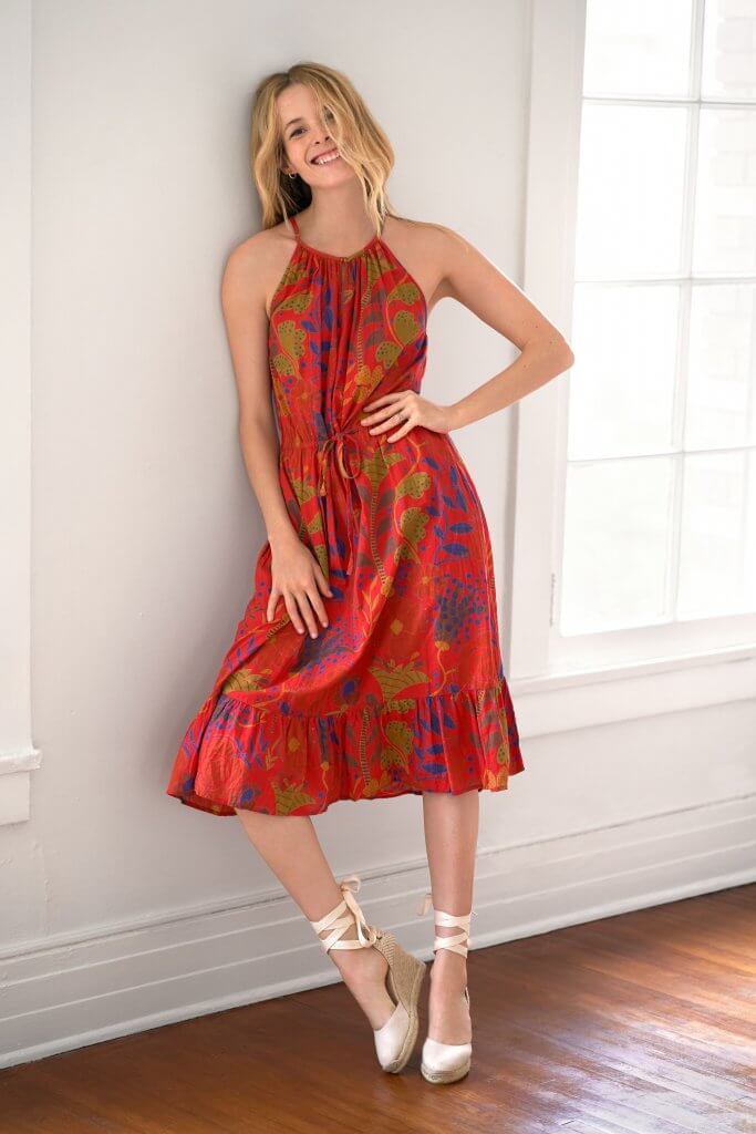 Stitch Fix model wearing gold hoop earrings, a red halter dress with a botanical pattern and lace-up off-white wedges.