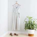 Stitch Fix Women’s Collection featuring grey and green vertical striped jumpsuit with tie waist detail and green sandals.