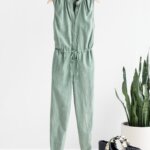 Stitch Fix Women’s Collection featuring light green jumpsuit with drawstring waist, black sandals and black straw tote.
