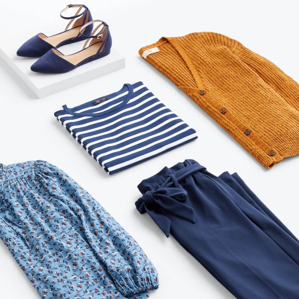 Stitch Fix women’s navy and orange outfit with striped T-shirt, navy pants, orange cardigan, floral blouse and navy flats.