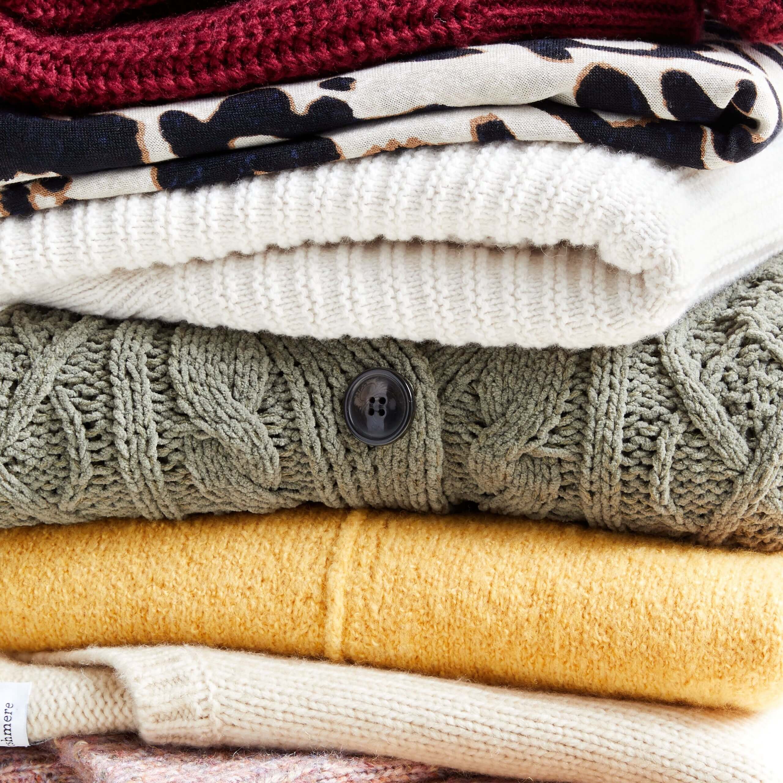 Stitch Fix Women's stack of sweaters in burgundy, beige and brown animal print, cream olive green, yellow and beige. 