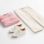 Stitch Fix women’s outfit laydown featuring gold accented white sneakers, pink and blue striped sweater and beige wide-leg pants.