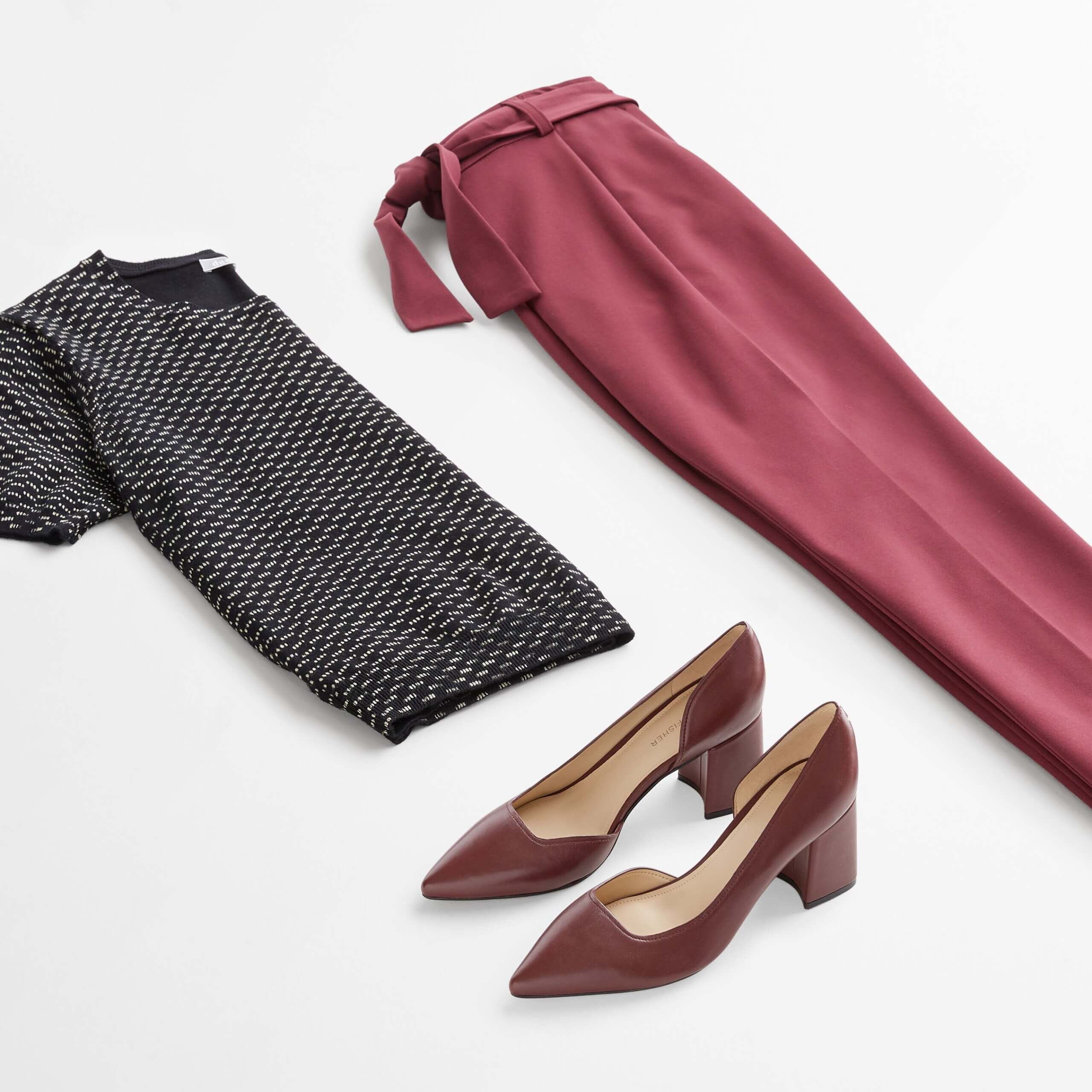 Stitch Fix women’s business casual outfit with black geo-printed short-sleeve sweater, burgundy tie-waist pants and burgundy heels.