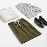 Stitch Fix women’s workleisure outfit with white cable-knit sweater, grey and white striped top, olive knit skirt and printed flats.