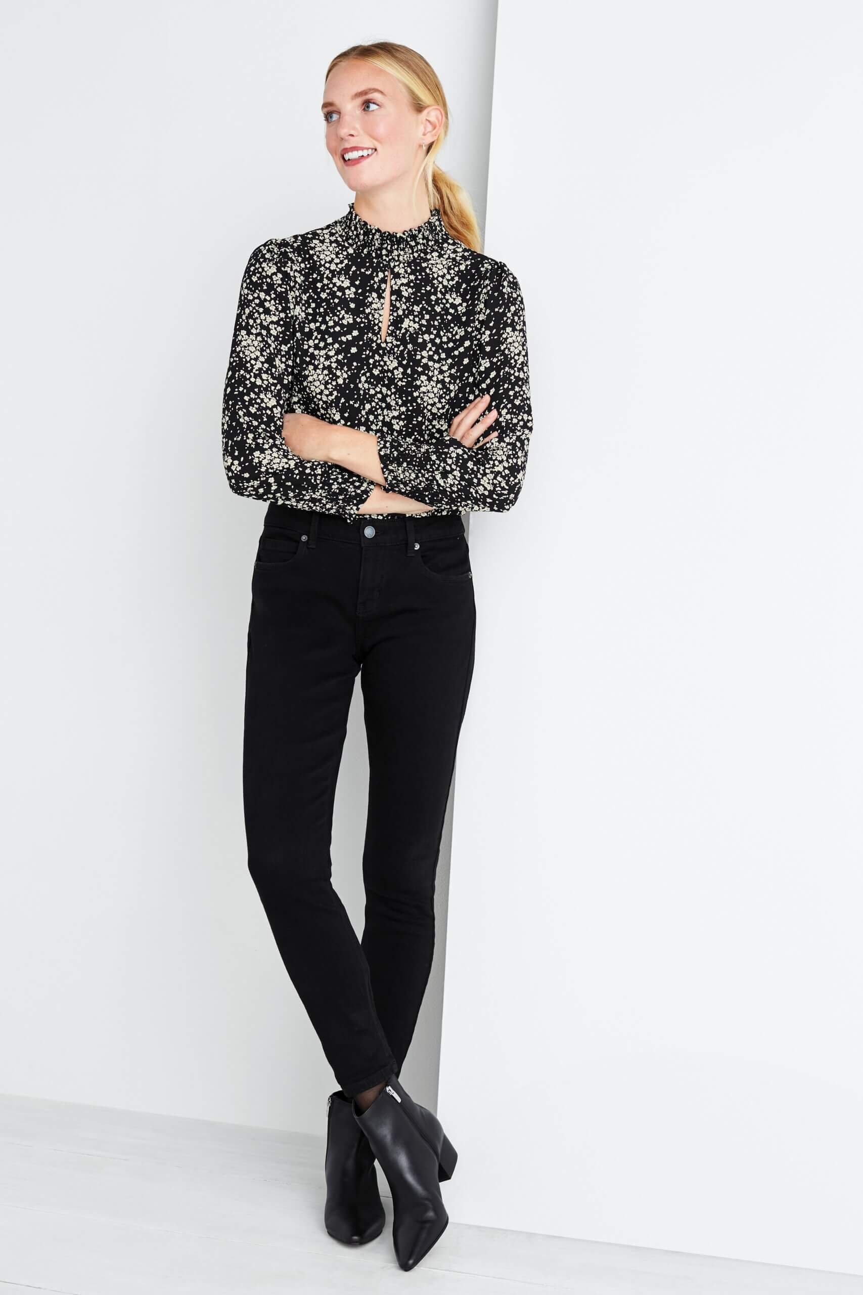 Stitch Fix women's model wearing black tucked in blouse, black skinny jeans and heeled black booties. 