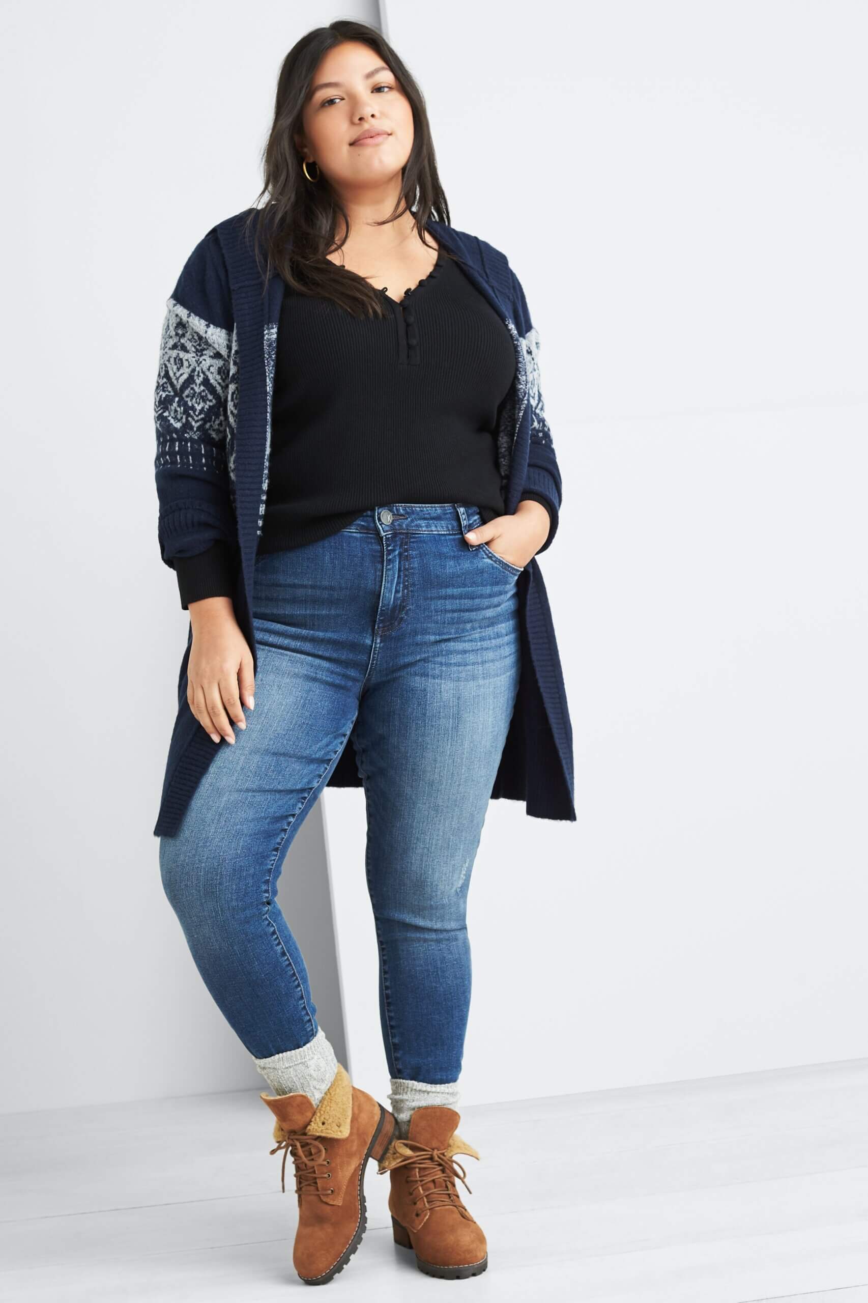 Stitch Fix Women's model wearing navy pullover, navy fair isle hooded cardigan, grey socks over her blue jeans and brown combat booties. 