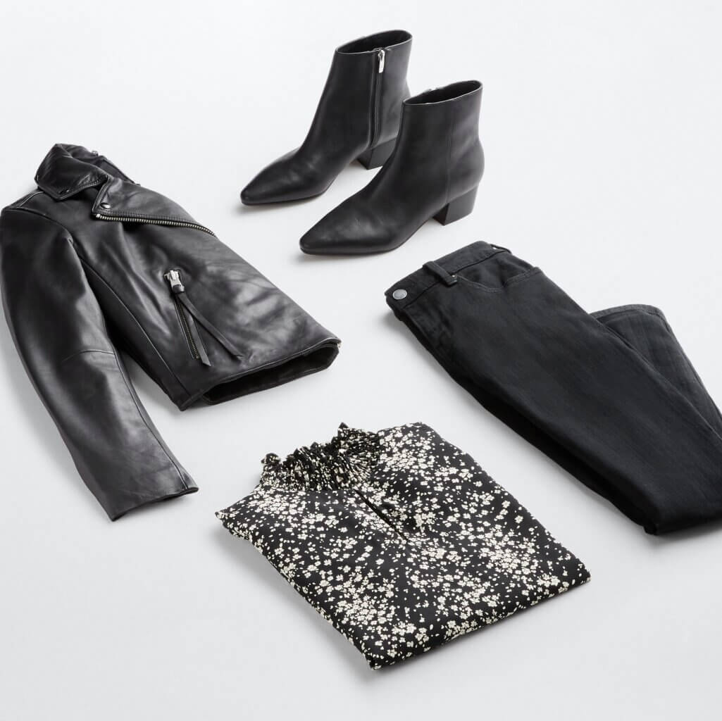 Stitch Fix women’s business casual outfit with black jeans, black and white blouse, black leather jacket and boots with silver hardware.