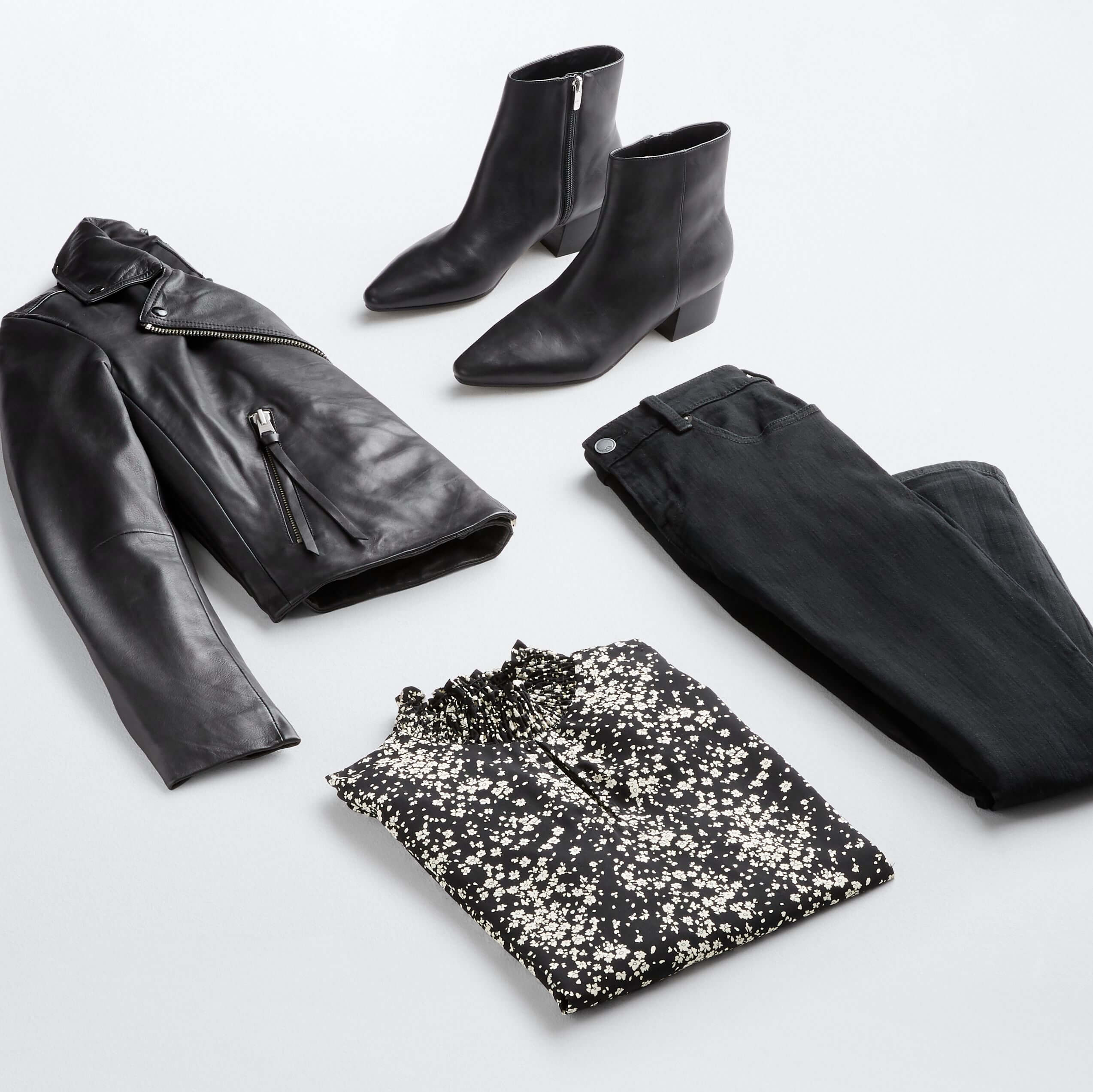 Stitch Fix women’s business casual outfit with black jeans, black and white blouse, black leather jacket and boots with silver hardware.