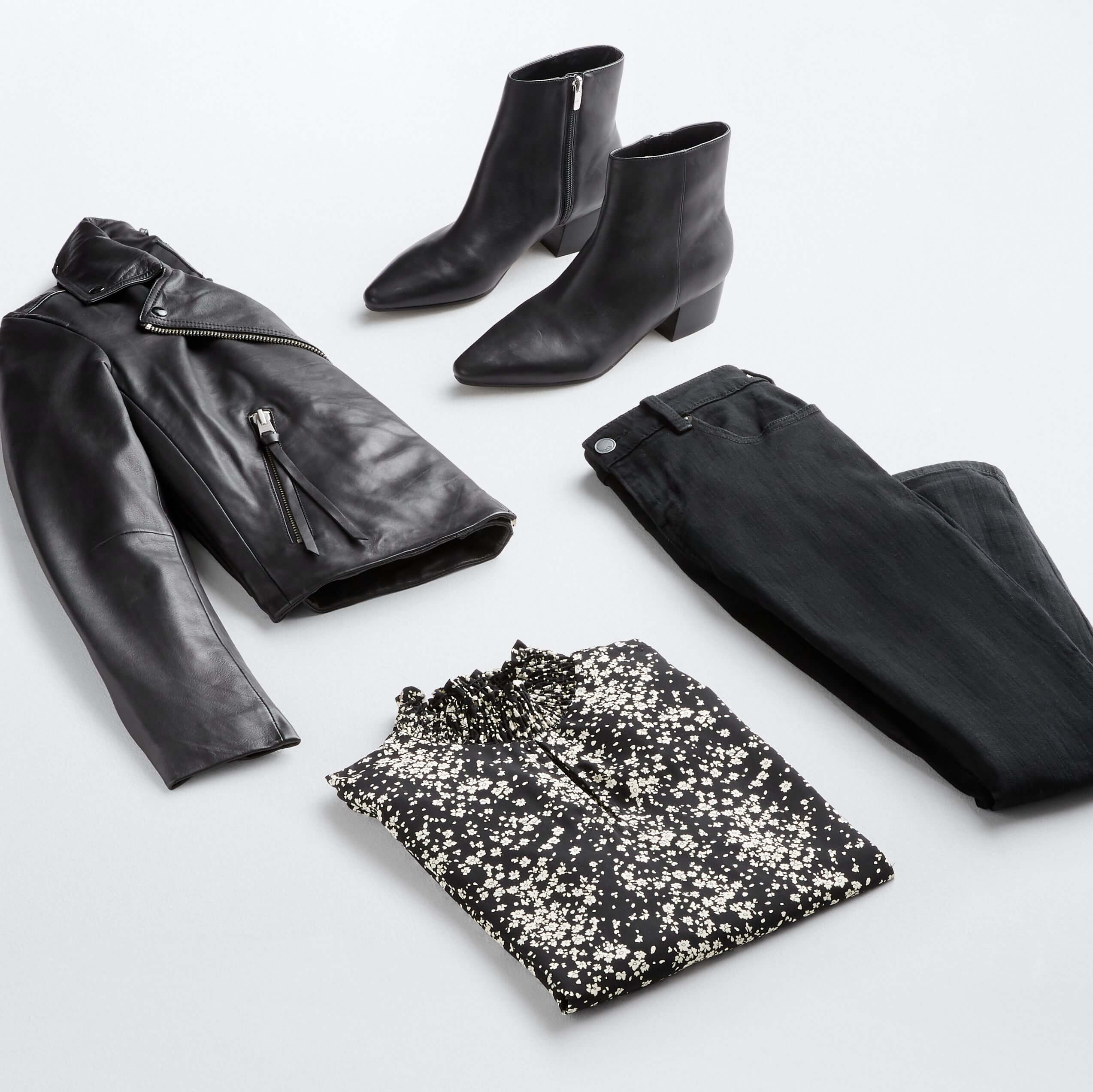 Stitch Fix Women's outfit laydown featuring a black leather jacket, black booties, black jeans and a black mock-neck printed top.