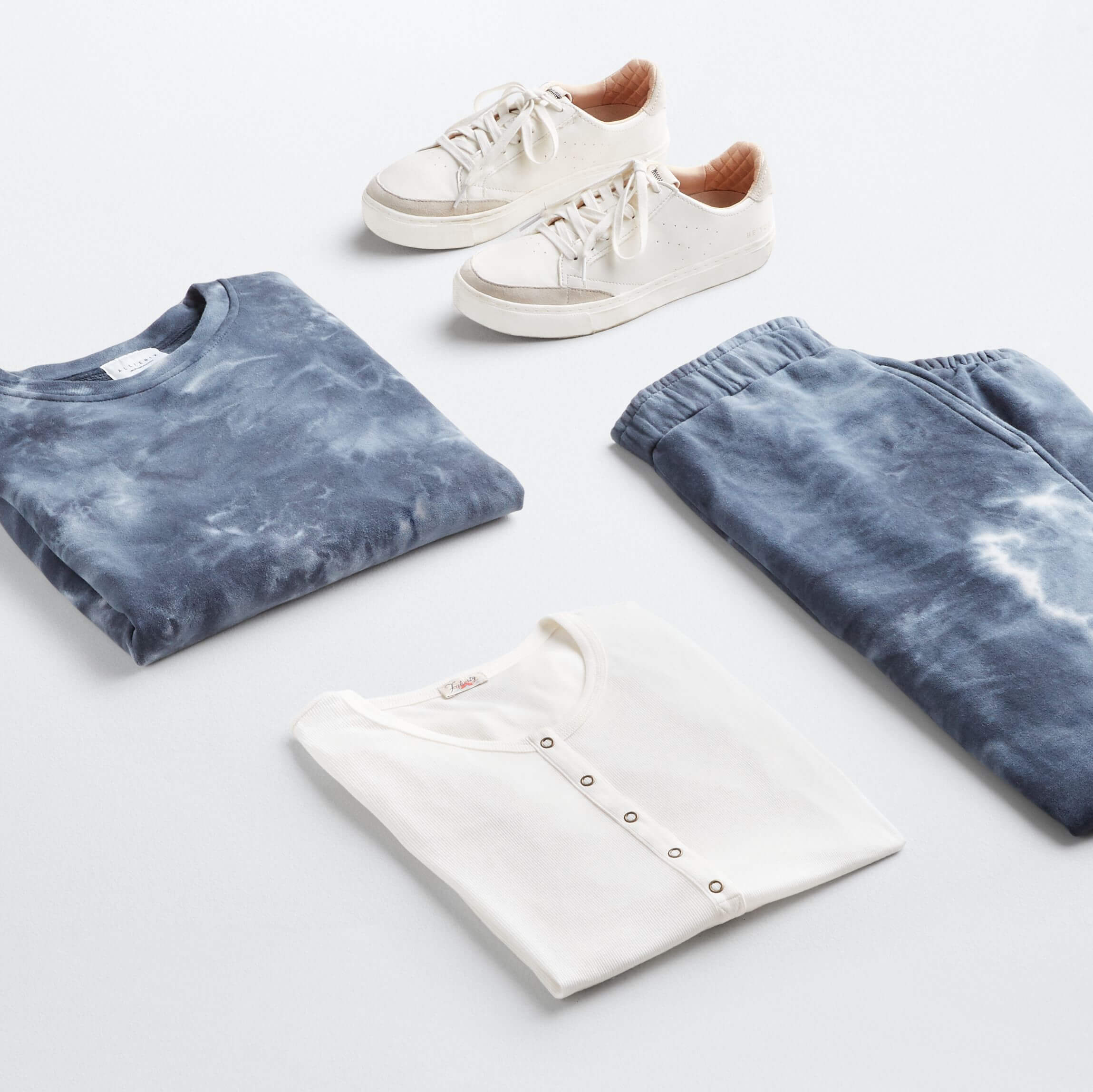 Stitch Fix Women’s Outfit featuring tie-dye loungewear set, white Henley T-shirt and white sneakers.