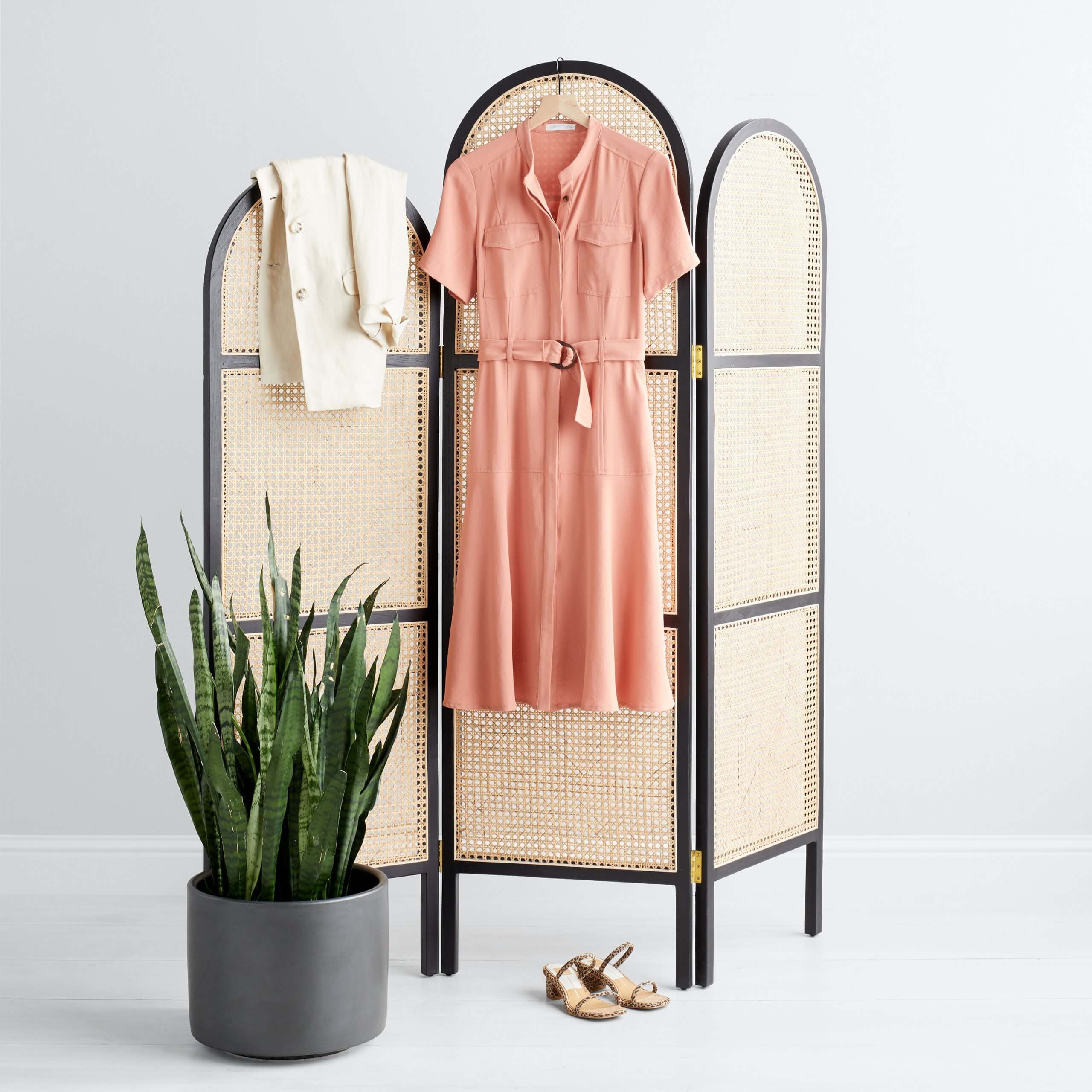 Stitch Fix Women’s pink tie-waist shirt dress and cream blazer hanging on room divider with tan heels on the floor. 