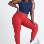 Stitch Fix women’s model wearing plus-size navy cropped tank, red textured leggings and red and blue accented white sneakers.