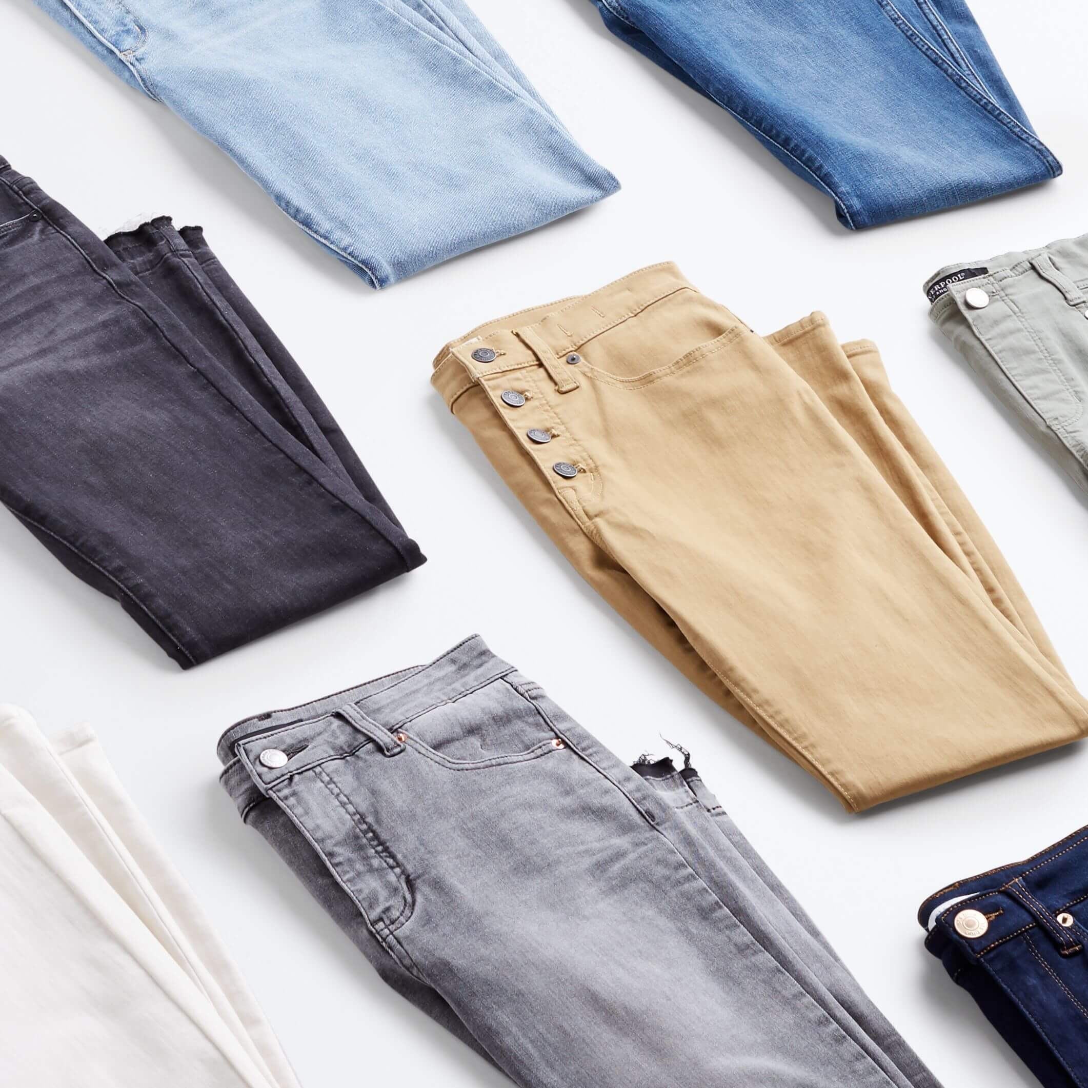 Stitch Fix Women’s jeans in blue, gray, white and khaki folded in half.