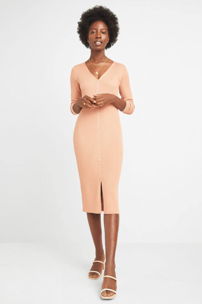Stitch Fix model wearing stud earrings, gold layered necklace, a peach midi sweater dress and nude slip-on heels.