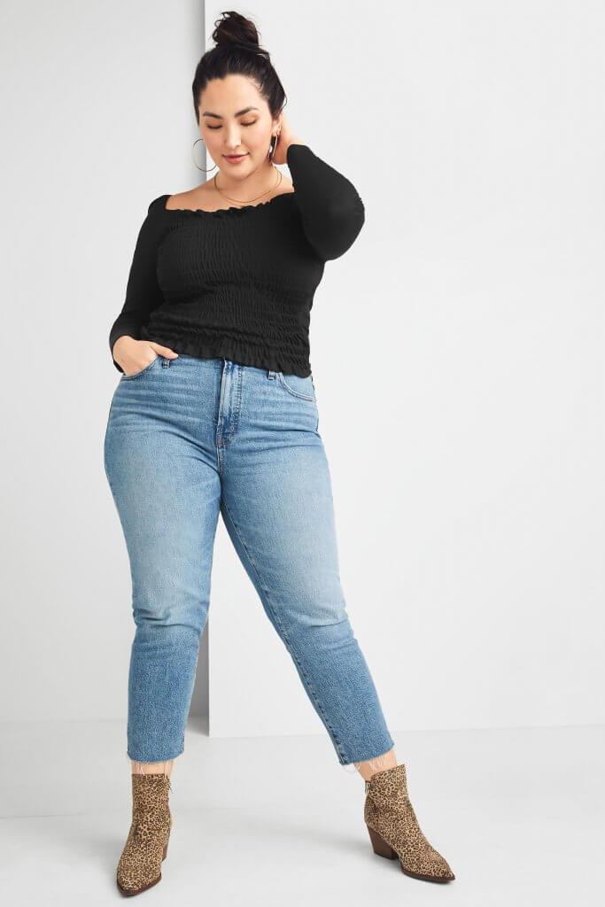Stitch Fix model wearing large hoop earrings, a black smocked top, light-wash straight jeans and leopard-print booties.