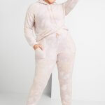 Stitch Fix women’s model wearing matching plus-size pink tie-dye hoodie and joggers with off-white sneakers.