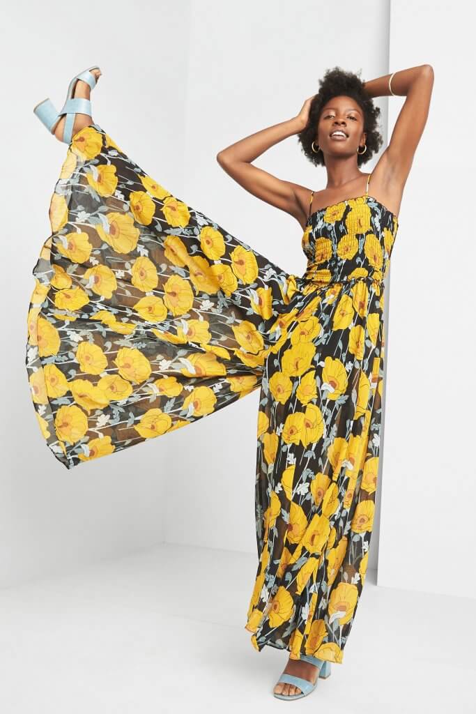 Stitch Fix model wearing gold hoop earrings and bracelet, floral jumpsuit and light blue heels.