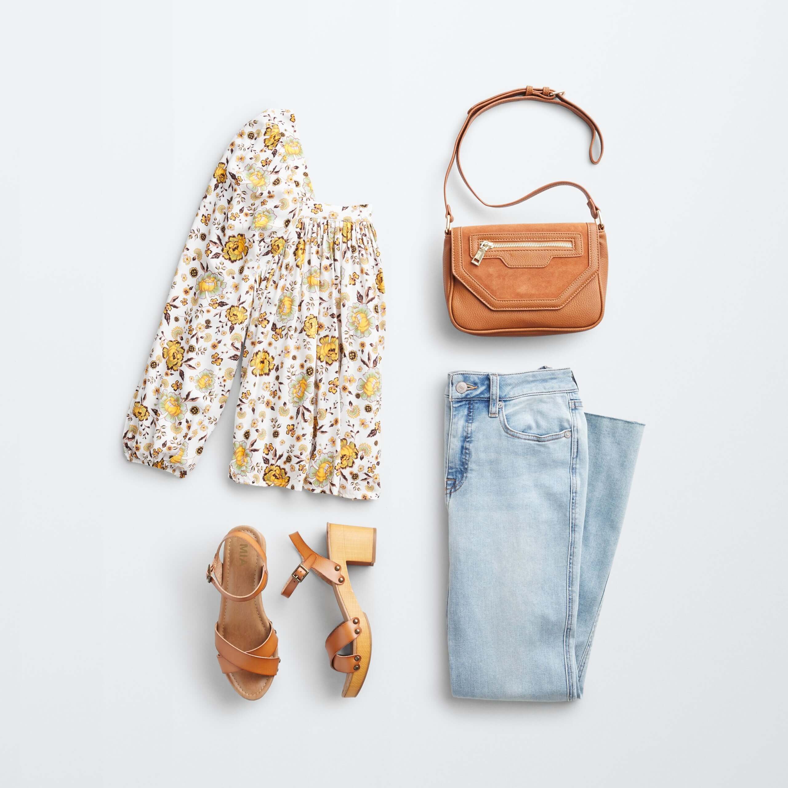 Stitch Fix Women's outfit laydown featuring white boho blouse with yellow florals, brown wooden heels, light wash cropped flare jeans and brown crossbody bag. 