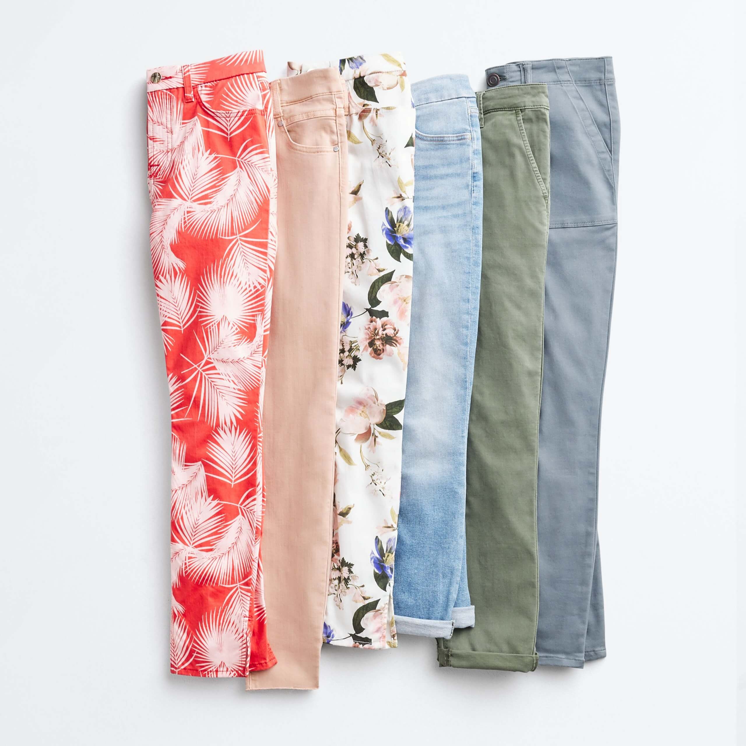 Stitch Fix Women’s outfit laydown of skinny jeans in orange tropical print, blush pink, white floral, light blue, olive green and light blue.