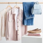 Stitch Fix women's shacket outfit featuring a white sweater, pink shacket over white T-shirt, blue jeans and light blue backpack on rack next to animal print flats on a stack of books.