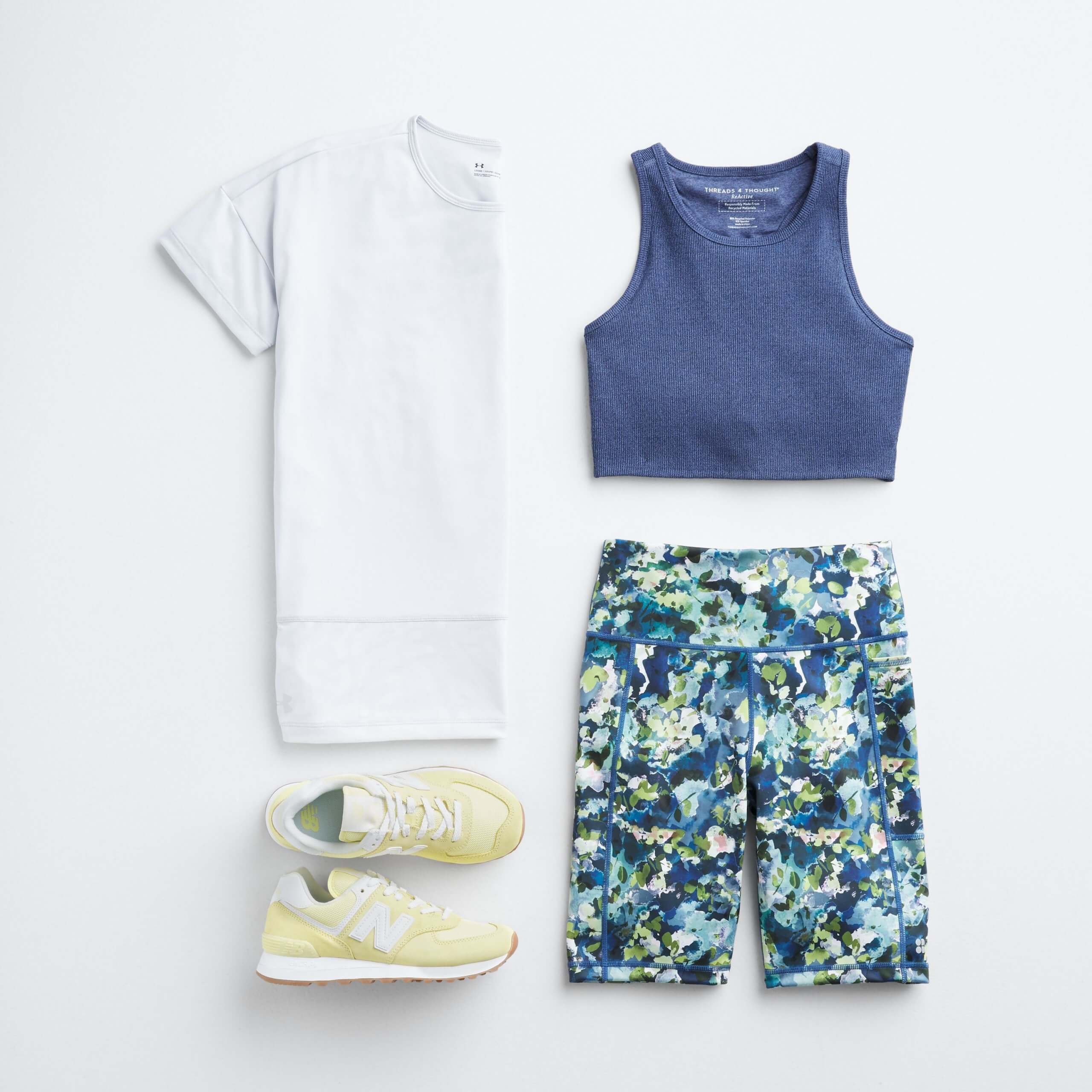 Stitch Fix Women’s outfit laydown featuring white performance tee, blue sports bra, blue white and green splatter-print yoga shorts and yellow sneakers. 