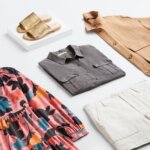 Stitch Fix women’s laydown with different types of fashion styles featuring pink printed dress, grey button-up shirt, white shorts, tan shacket and gold sandals.