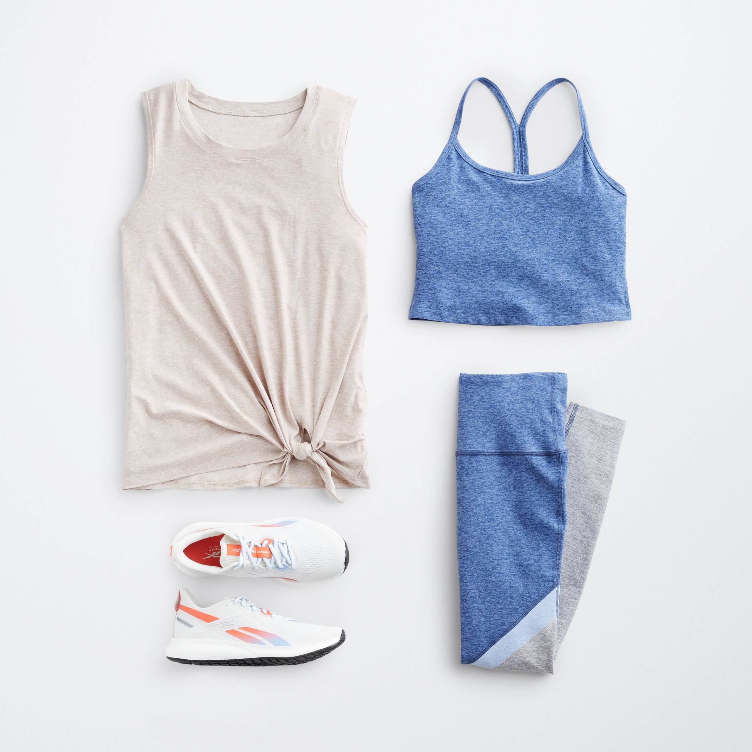 Stitch Fix Women’s outfit laydown of off-white tank-top with tie front, blue cropped sports top, blue and grey leggings and white sneakers with orange details.