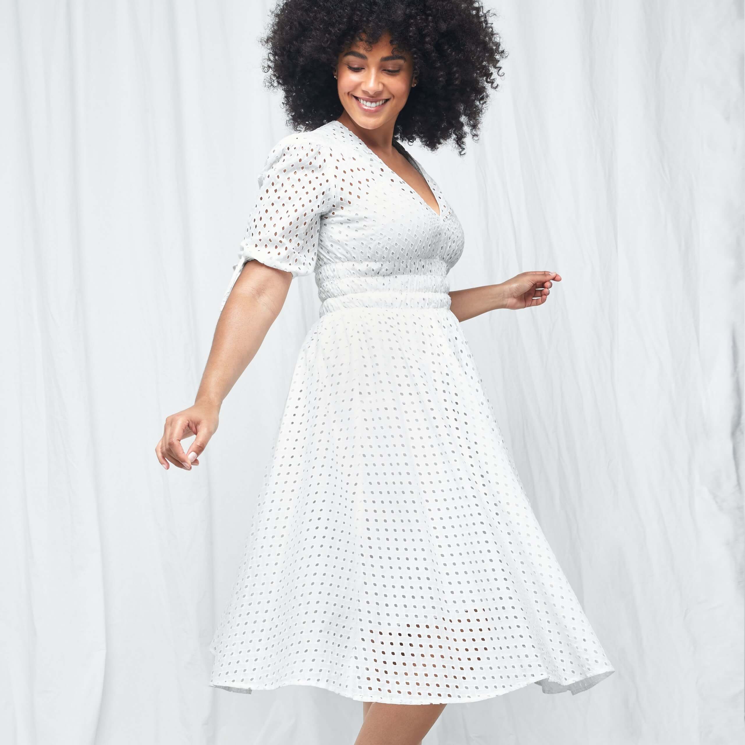 Stitch Fix women’s model in engagement party outfit with short-sleeve white eyelet dress.