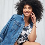Stitch Fix women’s model in chic style outfit featuring blue and white tie-dye T-shirt and denim jacket.