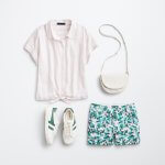 Stitch Fix women’s outfit laydown featuring green and white sneakers, pale pink striped shirt, printed shorts and white crossbody bag.