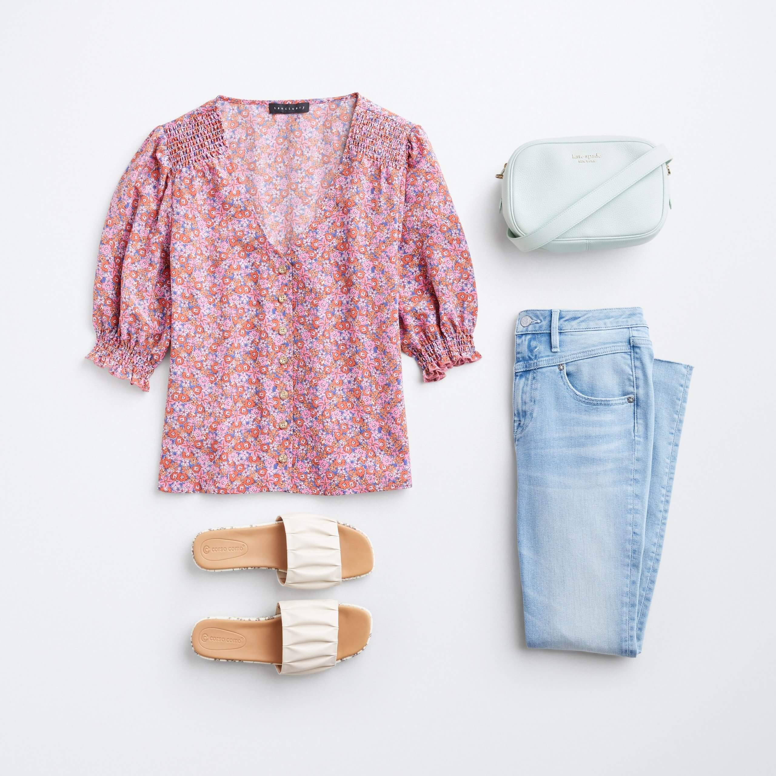 Stitch Fix Women’s outfit laydown featuring multi-colored floral print top with mint green crossbody bag, light blue jeans and white slide sandals.