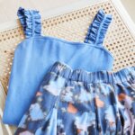 Stitch Fix women’s bodysuit outfit with blue ruffle strap bodysuit and multi-colored abstract print skirt.