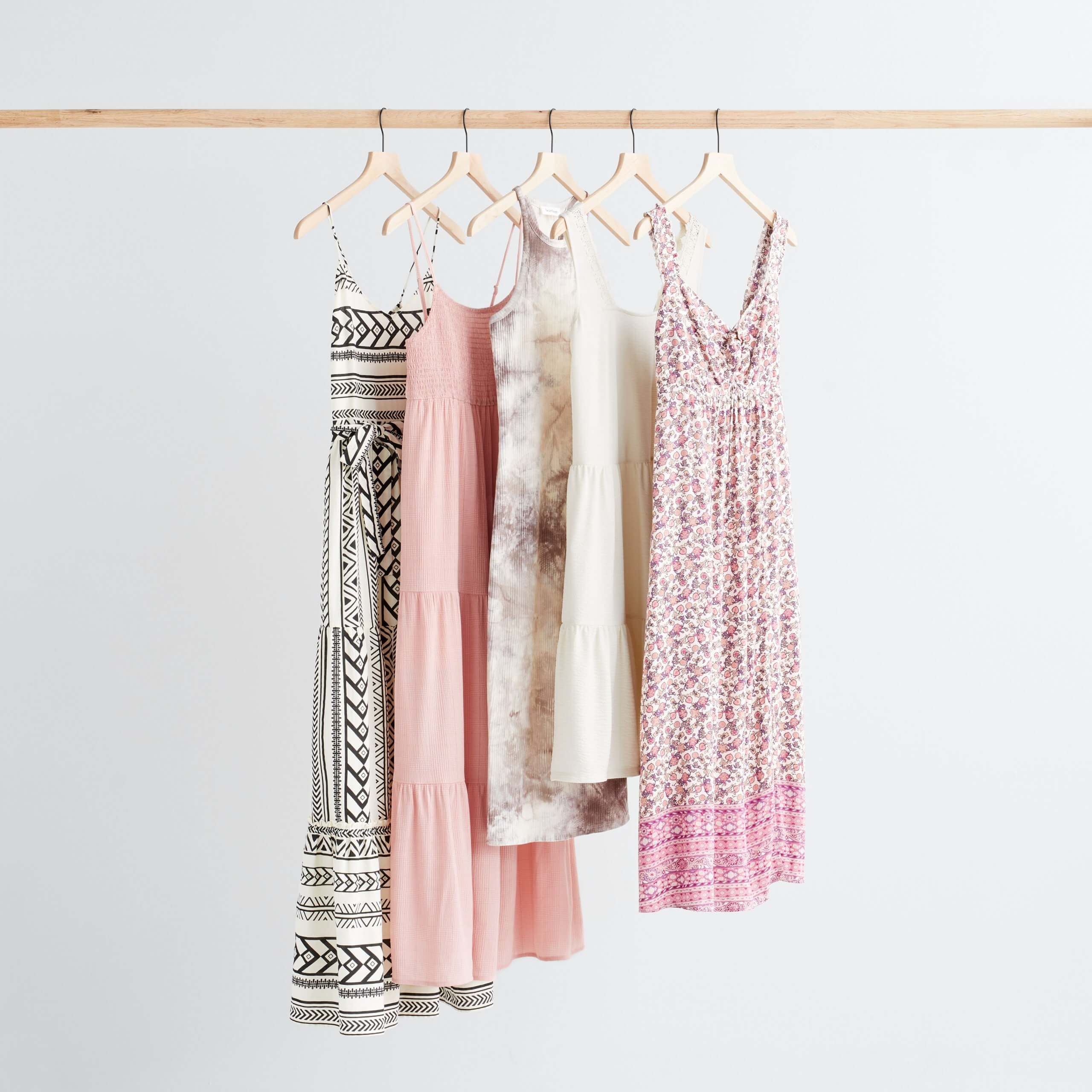 Stitch Fix Women’s boho style dresses hanging in a variety of colors, prints and lengths.