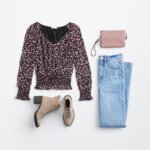 Stitch Fix women’s boots with jeans outfit featuring multi-colored smocked blouse, pink wristlet bag, light-wash jeans and tan ankle boots.