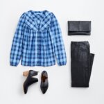 Stitch Fix women’s boots with jeans outfit featuring blue plaid balloon-sleeve blouse, black fold-over clutch, black coated jeans and black ankle boots.