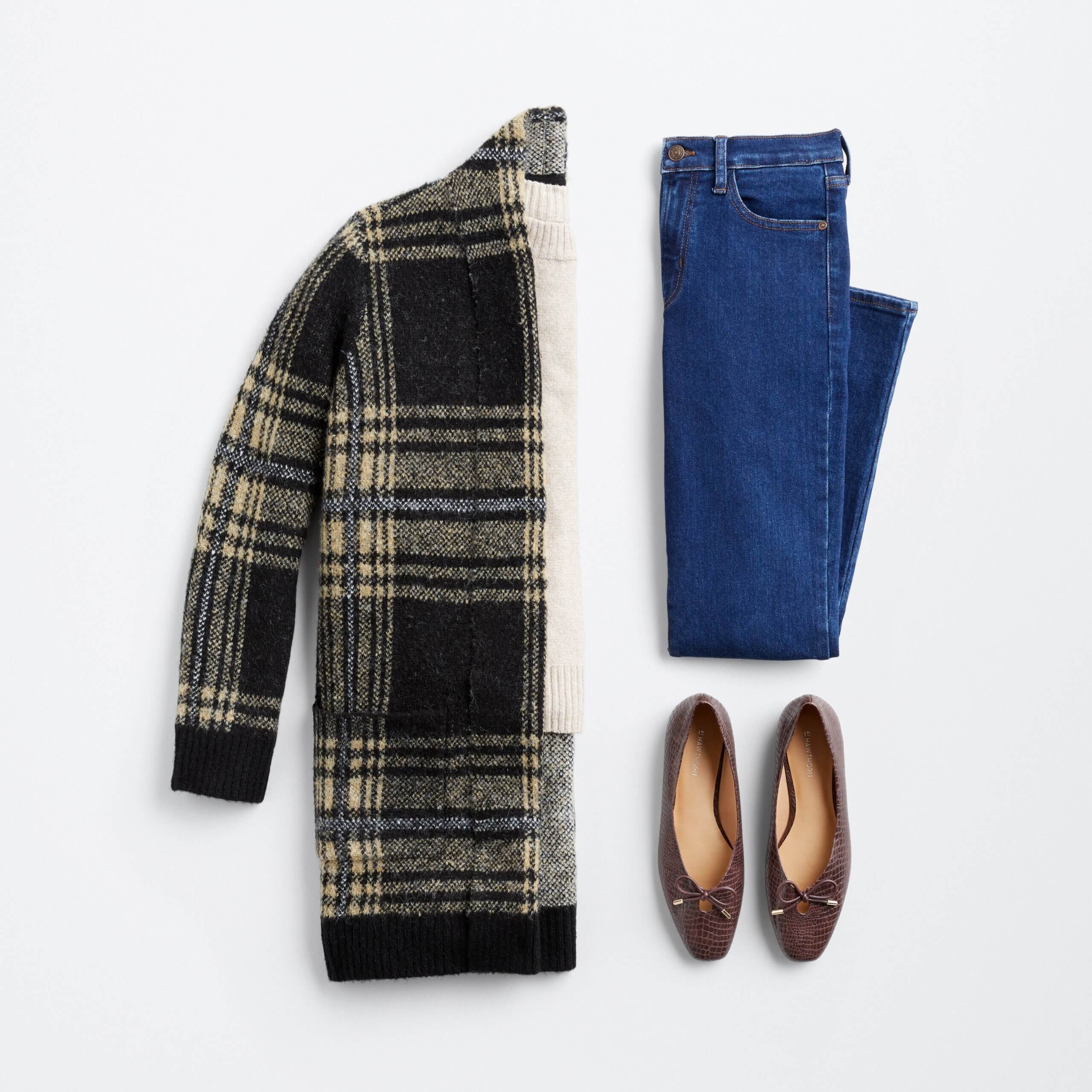 Stitch Fix women’s casual outfit with beige pullover, black and beige plaid cardigan, blue jeans and brown flats with gold accents.